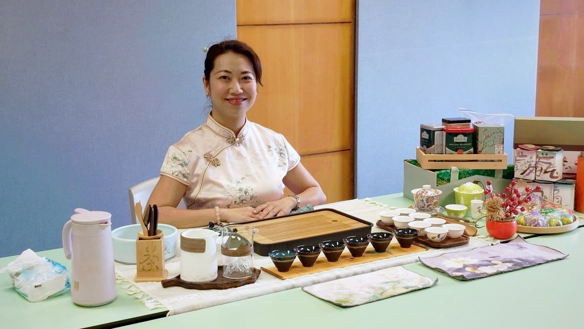 本會導師穿著旗袍,坐在佈置好的茶席前準備茶藝工作坊